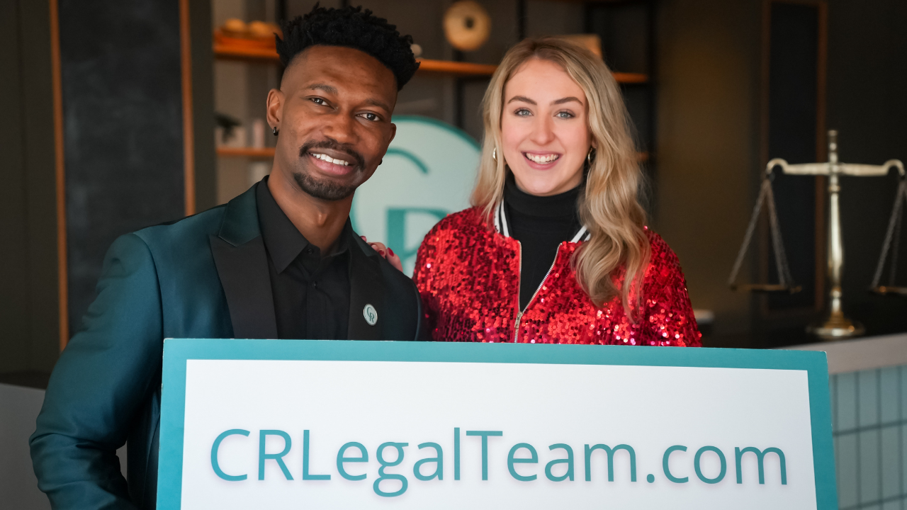 Team members holding CRLegalTeam.com sign.